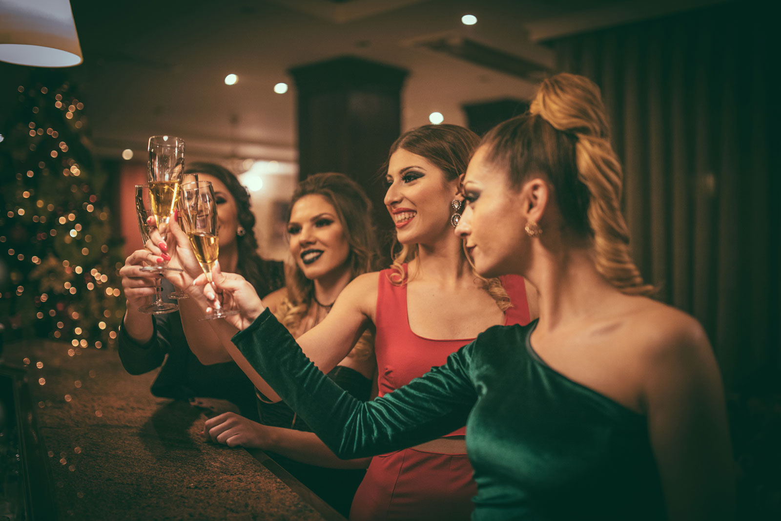 Four women toast champagne at a corporate event during the holidays