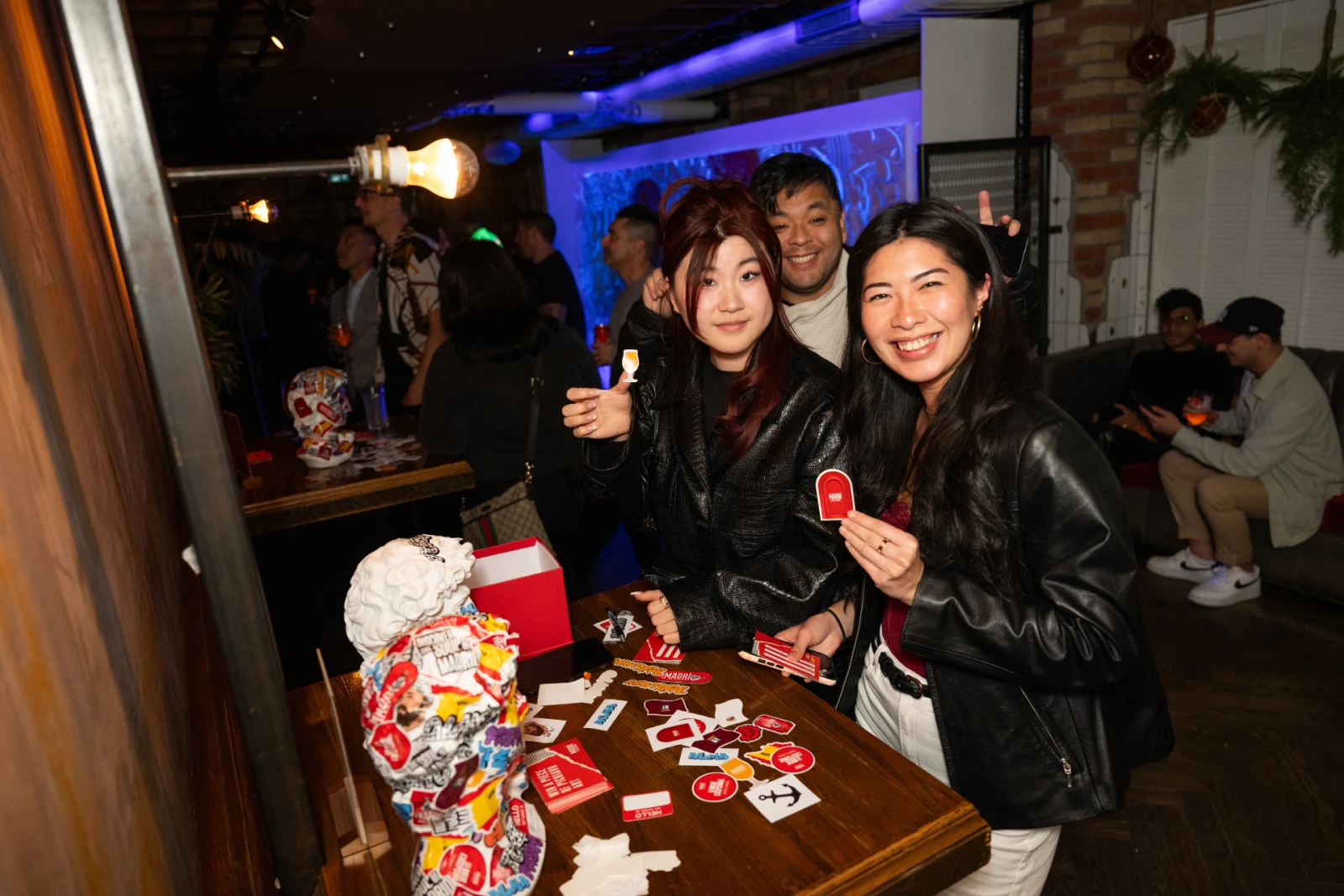 Event attendees holding stickers at the arts and crafts section for the Madri launch party in Toronto