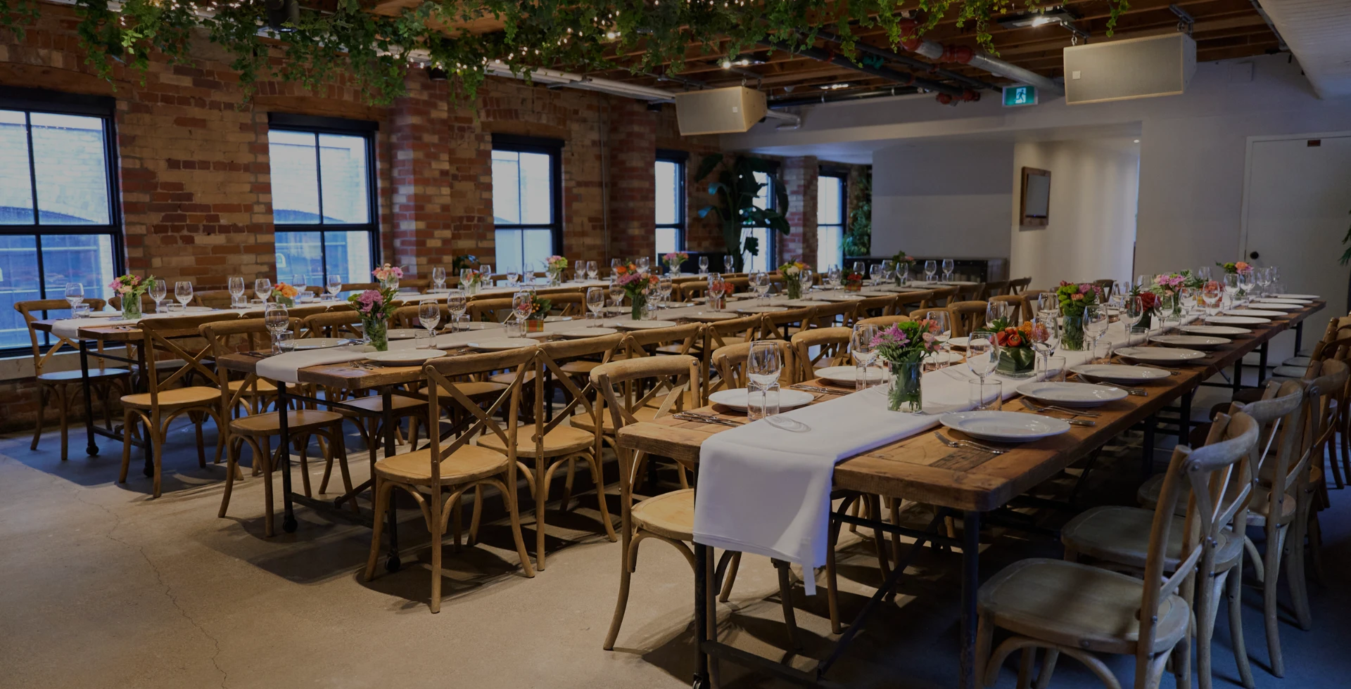 An elegant private dining room set up with three rows of tables at The Loft on King in Toronto