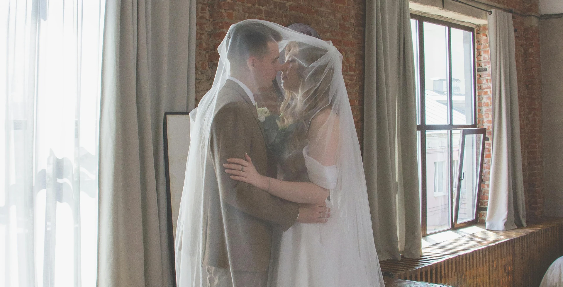 A newlywed couple staring at each other in loft-style venue
