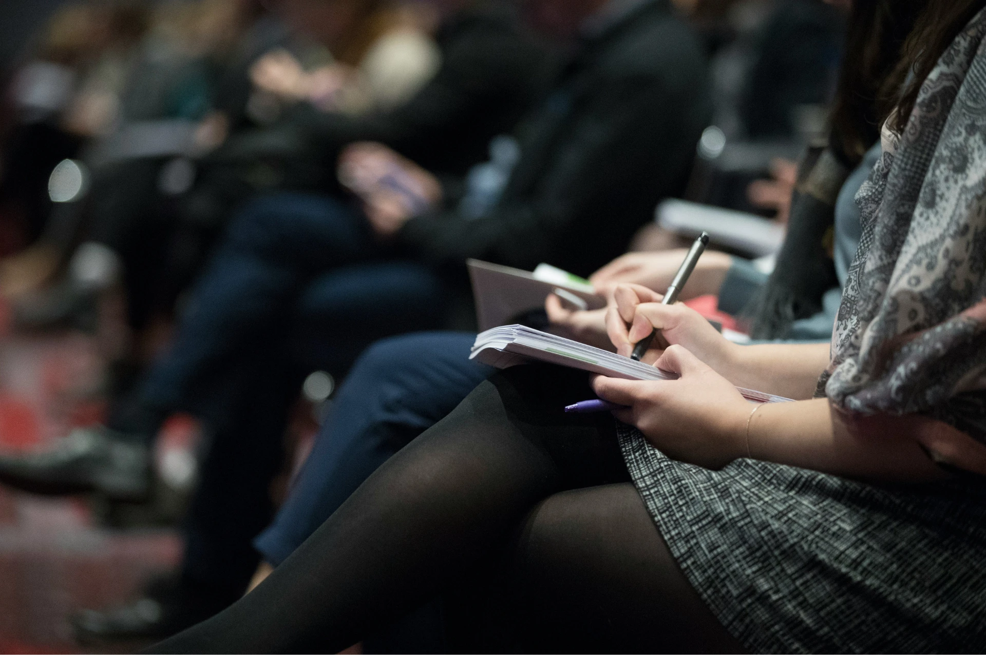A room of seated people taking notes at a seminar.