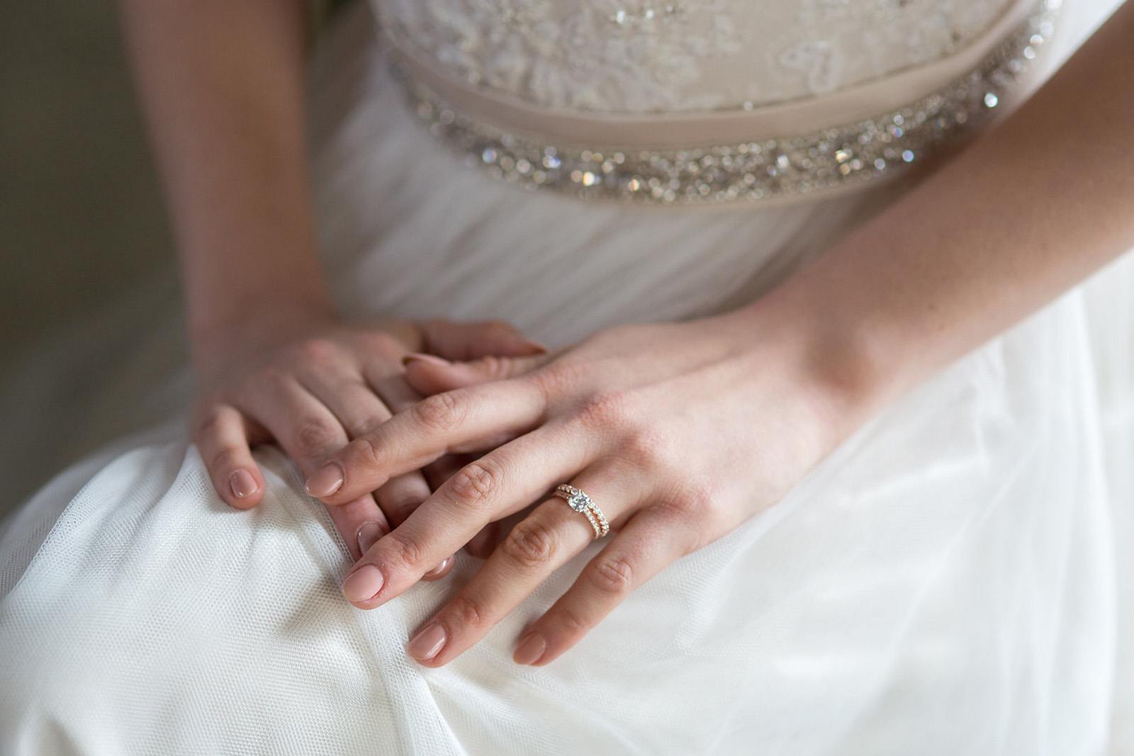 A woman wearing an engagement ring in a wedding dress