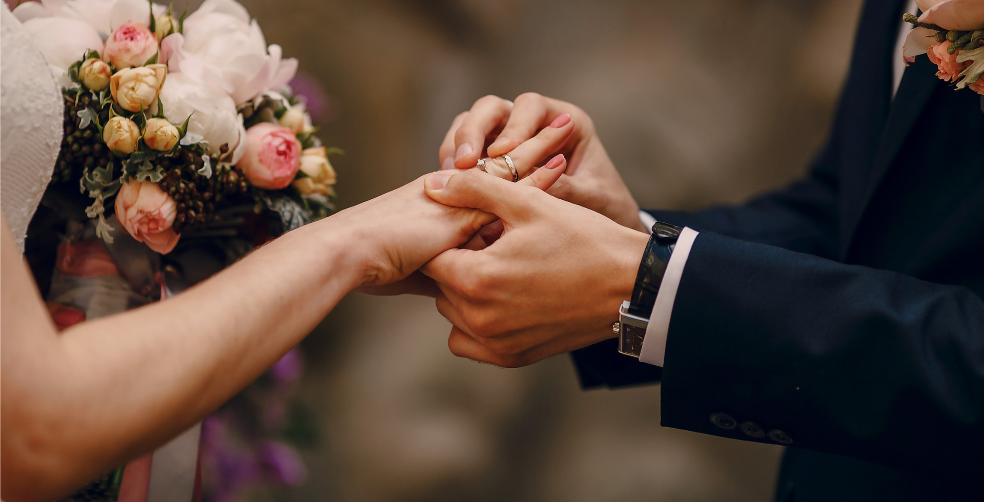 A newlywed couple putting on their rings